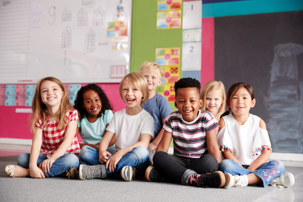 Enfants heureux dans une classe avec une environnement coloré